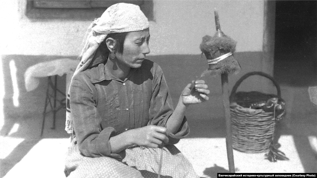 A spinner during the 1920s. Women's clothes were wide and long with shirts below the knees, long dresses with wide sleeves, as well as colored harem pants. Outer clothing was a tight-fitting caftan, or robe, with narrow sleeves. A short fur coat was worn over the caftan.