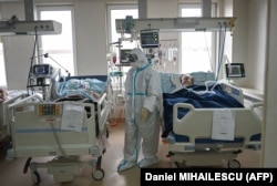 Személyi védőfelszerelést viselő egészségügyi személyzet ápolja a súlyosCOVID-19 betegeket a chisinau-i az "Sürgősségi Intézet" intenzív osztályán 2021. március 24-én.