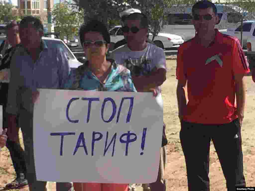 Участница митинга держит плакат: "Стоп тариф!"