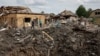 Люди стоять біля зруйнованих житлових будинків на місці російського ракетного удару в Покровську, 24 червня 2024 року