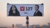 Workers in the Kosovar capital, Pristina, install a giant election poster showing prime ministerial candidate Albin Kurti (right) and acting President Vjosa Osmani. 