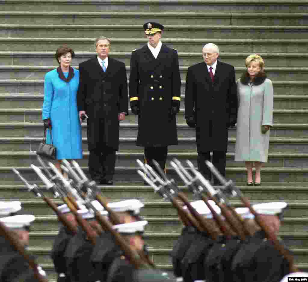 Prezident kiçi Jorj W. Buş we onuň aýaly Lora (çepde) 2001-nji ýylyň 20-nji ýanwarynda kasam kabul ediş dabarasyndan soň, wise-prezident Dik Çeni we onuň aýaly Linn (sagda) bilen Kapitolyň basgançagynda. Buş iki möhlete prezident boldy. 