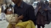 A volunteer carries a child injured in a car bomb blast in Peshawar on November 16.