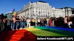 People unfurl a rainbow flag during an LGBT rights demonstration in front of the Hungarian parliament building in Budapest on June 14.
