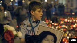 Portretul Mariei Kaczynska purtat de un tînăr la Varșovia 