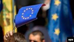People wave EU flags in front of Moldova's parliament during the ratification of the Association Agreement between Moldova and EU in July, 2014.