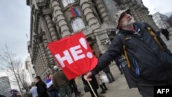 Un protestatar în fața sediului guvernului la Belgrad