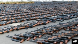 Assault rifles and missiles seized by the French Navy lie on the deck of a ship at an undisclosed location on February 1. 