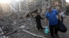 Residents carry some belongings as they walk amid the aftermath of an Israeli strike that targeted the Sfeir neighborhood in Beirut’s southern suburbs on October 6.