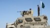 Security personnel of Pakistan's Frontier Corps stand on an armoured vehicle near a border crossing point between Pakistan and Afghanistan in Balochistan Province.