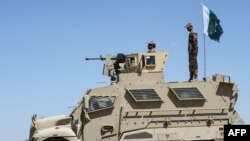 Security personnel of Pakistan's Frontier Corps stand on an armoured vehicle near a border crossing point between Pakistan and Afghanistan in Balochistan Province.