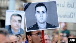 Hungary -- Activists and sympathizers of Hungarian 'Milla' Group lift a photo of Armenian Army Lieutenant Gurgen Margarian (C), beside a picture of Hungarian Prime Minister Viktor Orban (L), in front of parliament building in Budapest, 04Sep2012