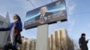 Молодая женщина с цветами проходит мимо предвыборного билборда Нурсултана Назарбаева. Астана, 31 марта 2011 года. Иллюстративное фото.