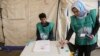 Afghan employees of the Independent Election Commission wait to register residents at a voter-registration center for the upcoming parliamentary and district council elections in Kabul last month.