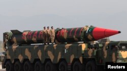 Pakistani military personnel stand beside a Shaheen III surface-to-surface ballistic missile during a military parade on March 23, 2017.