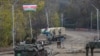NAGORNO-KARABAKH -- Russian APC and soldiers of the peacekeeping force (L) patrol in front of an Azerbaijan's army checkpoint near the demarcation line outside the town of Shushi (Susa), November 26, 2020