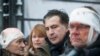 Former Georgian President Mikheil Saakashvili (center) speaks to people wounded during clashes with police in Kyiv on December 6.