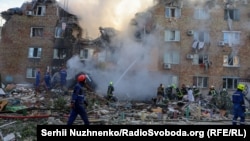 Firefighters and rescuers work at the site of a residential building hit by a massive Russian missile attack on Kyiv on August 28.