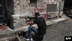 Syria -- A Syrian rebel takes position on a street in the northern city of Aleppo, 03Aug2012