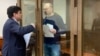 Vladimir Kara-Murza (right) talks to his lawyer, Vadim Prokhorov, during a preliminary court hearing in Moscow on March 6.