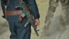 A member of the Afghan National Police walks behind a U.S. Army soldier during a joint patrol in Kandahar Province. So-called "green-on-blue" attacks are often attributed to cultural differences.