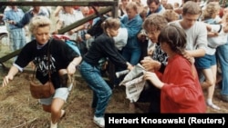Est-germani fugind din lagărul comunist în spațiul european prin gardul care separa Ungaria de Austria lângă Sopron. 19 august 1989