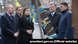 Ukrainian President Petro Poroshenko (second from right), his wife, Maryna (third from left), and other officials placed flowers and lit candles on Independence Square in Kyiv on November 21.