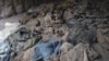 Human skeletons and items of clothing are seen in a mass grave uncovered in northern Balkh Province in January. Construction workers digging a car park found at least 10 human skulls.