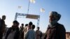 Afghan men stand near the Afghanistan-Iran border crossing of Islam Qala, on Nov. 24, 2021.
