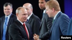 Russian President Vladimir Putin (left) shakes hands with Myron Brilliant, executive vice president and head of international affairs at the U.S. Chamber of Commerce, during a session of the St. Petersburg International Economic Forum on June 2.