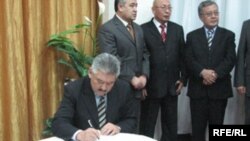 Азимбек Бекназаров БЭКтин билдирүүсүнө кол коюп жатат.