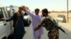 Afghan soldiers search people at a checkpoint on a highway leading to the Maiwind district of restive Kandahar Province on October 19.