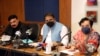 Information Minister Fawad Chaudhry (center) and Human Rights Minister Shireen Mazari (right) talk with journalists during a press conference in Islamabad in April 2021.