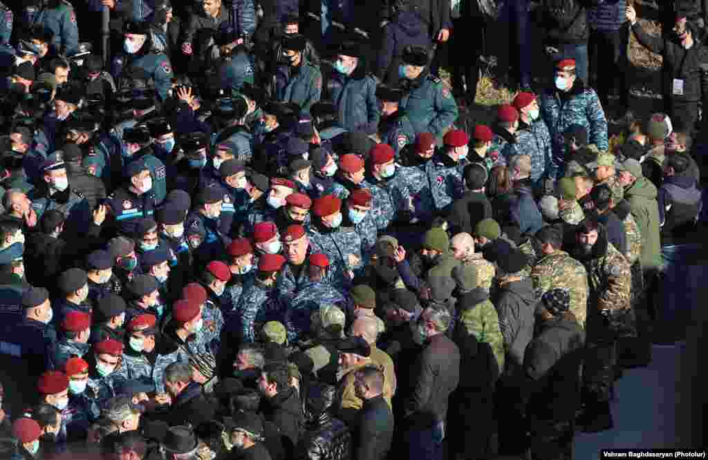Armenian police stand guard as Pashinian pays his respects at the military cemetery on December 19. 
