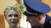 Полицейский что-то говорит Юлии Тимошенко сразу же после оглашения приговора. Киев, 11 октября 2011 года.