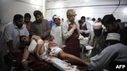 Paramedics treat an injured man in a hospital in Peshawar after a suicide blast in Mardan on June 18.