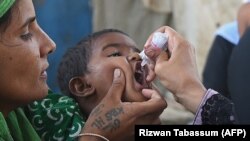 A health worker administers polio vaccine drops to a child during a polio vaccination campaign in Karachi on June 7.
