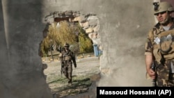 FILE: Afghan soldiers near a hole in a wall made to rescue people from the Shamshad TV building after a deadly attack in Kabul on November 7, 2017.