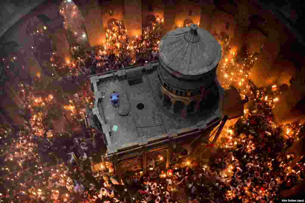 Основна заслуга появи наступного кадру – особисті зв'язки фотографа ЕРА Абір Султана: без них йому не вдалося б зняти церемонію запалювання благодатного вогню в Храмі Гробу Господнього в Єрусалимі. «Я дуже добре знаю заступника патріарха, тому я попросився в нього піднятися наверх і поспостерігати за церемонією», – розповідає фотограф. Він уже багато разів бував на цій точці, але саме в цей Абір відчував, що в нього має вийти особливий кадр. Він побачив, як чоловік забрався на дах Гробу. «Він припав до землі, немов молиться мусульманин. Лише на секунду». І Абір вдалося натиснути на кнопку в потрібний момент.