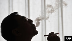 China's Hon Lik, inventor of the e-cigarette, tests his invention in Beijing.