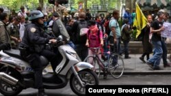 Still going strong? A police officer rides alongside an Occupy demonstration in New York in May.