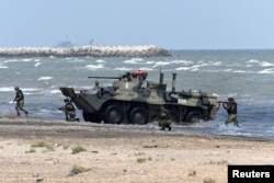 Russiýanyň deňiz pyýada goşuny “Turali” harby türgenleşik meýdanynda, “Merkez-2019” harby türgenleşik okuwy wagtynda, BTR-82A sowutly maşyny bilen Hazar deňziniň kenaryna çykýar. Russiýa, Dagystan, 2019-njy ýylyň 20-nji sentýabry.