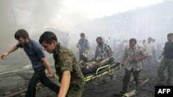 Dobrovoljci nose tijelo poginulog u bombaškom napadu