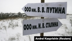 Росія. Вказівник в Алтайському краї в селі Горновка, який вказує, як дібратися до Товариства з обмеженою відповідальністю імені В.В. Путіна. А інший вказівник вказує напрямок до ТОВ імені Й.В. Сталіна. Село Горновка (архівне фото) 
