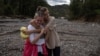 Two local woman react after floods and landslides hit the village of Trusina in Bosnia-Herzegovina. 