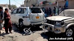 Local residents examine damaged vehicles at the site of a bomb blast in Chaman, southwestern Pakistan, on May 21.