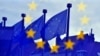 EU flags are reflected at the entrance of the Berlaymont building of the EU Commission in Brussels