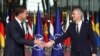 Mark Rutte (left) and Jens Stoltenberg shake hands as Rutte succeeds Stoltenberg as NATO chief at the alliance headquarters in Brussels on October 1.