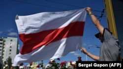 Бело-красно-белый флаг у одного из протестующих в Минске