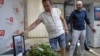 Arkady Babchenko (right) reacts as he arrives in the offices of ATR TV, where his colleagues laid flowers by a portrait of him in his memory, in Kyiv on May 31.